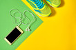 © mirage_studio - Sport shoes and mobile cellphone with earphones on colorful background. New sneakers on green and yellow background, copy space. Overhead shot of running shoes and smartphone. Top view, flat lay