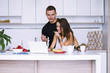 © mikitiger - cute young woman and man in white kitchen near table in house