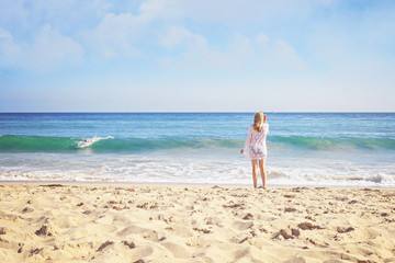 Blond Girl Watching Surfer Paddle Towards Shore