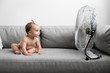 © Lisa Tichané - Baby girl sitting on couch next to fan