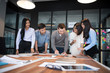 © Nattanon - Group of young modern people in casual wear planning business strategy. Business team analyzing income charts and graphs. Setup studio shooting.