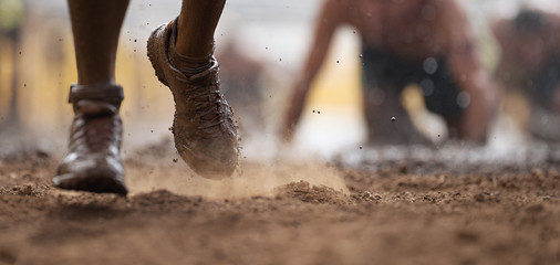 Mud race runners.Crawling,passing under a barbed wire obstacles during extreme obstacle race