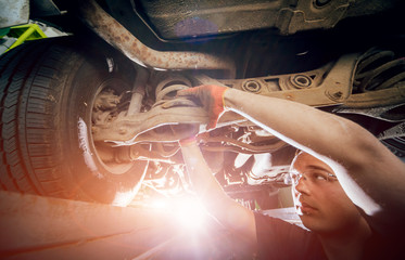 Wall Mural - Car mechanic repair car suspension of lifted automobile at repair service station