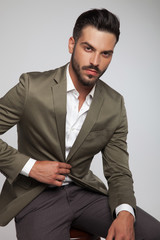 Canvas Print - portrait of seated handsome man wearing a green suit