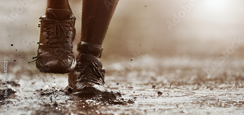 Fotografía Mud race runners detail of the legs,muddy running shoes a run in the mud