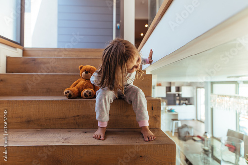 Fototapeta Little girl sitting on staircase at home