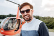 © Viacheslav Yakobchuk - Flight on helicopter. Optimistic cheerful man smiling and waiting near helicopter