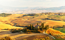 Italy. Pienza.  Beautiful Tuscany Autumn Rural Landscape With Cleaned Fields And A Farmhouse With Cypress Trees In The Setting Sun. Val D'Orcia Natural Park