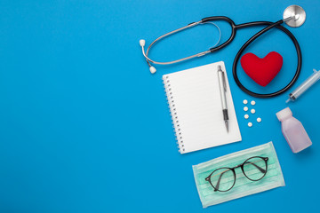 Wall Mural - Flat lay aerial of tools medical & Healthcare insurance background concept.space for design.Table top view essential items for doctor using treat & care patient in hospital.Objects on blue paper.