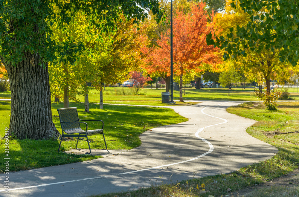 Autumn City Park - A sunny autumn afternoon view of a quiet running trail winding in a city park, Denver/Lakewood, Colorado, USA.  - obrazy, fototapety, plakaty 