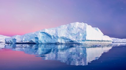 Wall Mural - antarctic nature. huge long iceberg with mirror reflection float in open ocean. dramatic sunset sky 