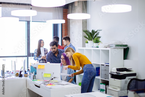 Well Lit White Open Office Space With White Furniture Computer Tables With Digital Gadgets Multiracial Emploee People Gathering Near Female Manager With Open Laptop Concept Of A Busy Office Life Buy This