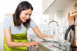 © JackF - Woman housewife in apron cleaning furniture at home kitchen