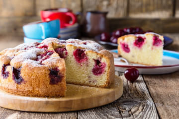 Wall Mural - Cherry cake and slice of cake on rustic table