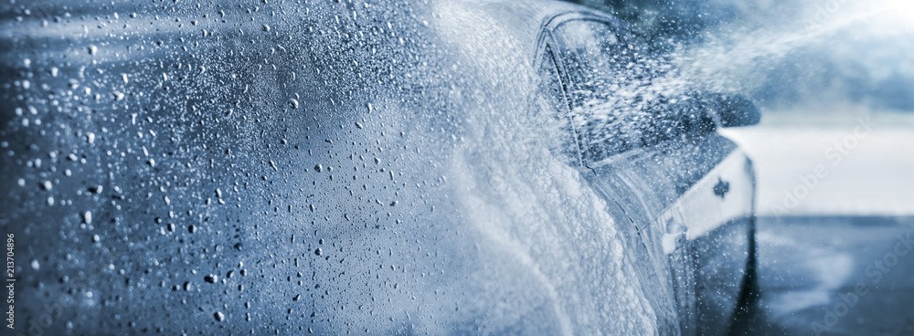 Abstract carwash banner, focus only on drops of water, jet spraying to car out of focus, toned in light blue color. - obrazy, fototapety, plakaty 