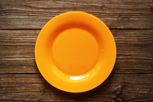 Empty Orange Plate On A Wood Background