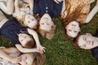 © Cavan Images - Overhead view of siblings lying on grassy field