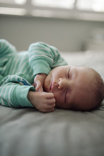 Close-up Of Cute Baby Boy Sleeping On Bed At Home