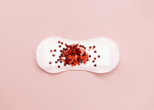 Menstrual Pad With Red Glitter On Pastel Colored Background. Minimalist Still Life Photography Concept