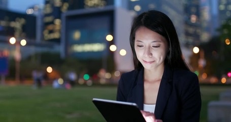 Wall Mural - Business woman watching on tablet computer at night