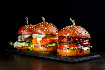 Set burgers with beef. On a black background.