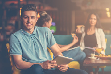 Wall Mural - Young male using digital tablet in modern startup office