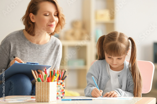 Fotografía Female psychologist with cute little girl during art therapy