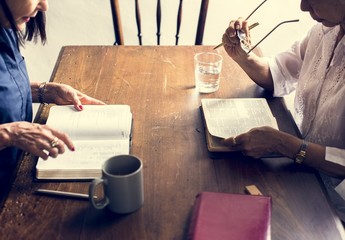 Two christianity people reading bible on the table