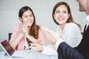 Boss/Business man employer admires young Asian business woman/staff/employee by clapping hands with smiling face for her success and good/best in work and recognition/appreciate.