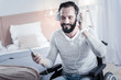 © Viacheslav Yakobchuk - Time to relax. Delighted brunette man keeping smile on his face while sitting on his wheelchair