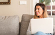 © Krakenimages.com - Young beautiful woman smiling using laptop on the sofa looking confident.