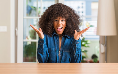 African american woman at home very happy and excited, winner expression celebrating victory screaming with big smile and raised hands