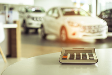 calculator for business finance on car showroom blurry background.for automotive automobile or transportation transport