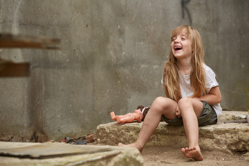 Wall Mural - Cute stray child on the street laughing and having fun in front of the camera.