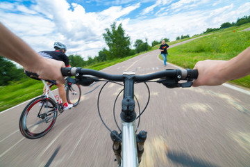 Rider driving bicycle on an asphalt road.