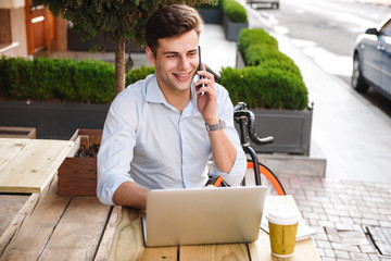 Poster - Happy young stylish man in shirt talking on mobile phone