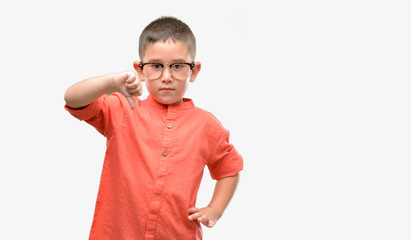 Sticker - Dark haired little child wearing glasses with angry face, negative sign showing dislike with thumbs down, rejection concept