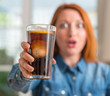 © Krakenimages.com - Redhead woman holding soda refreshment scared in shock with a surprise face, afraid and excited with fear expression