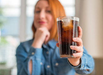 Sticker - Redhead woman holding soda refreshment serious face thinking about question, very confused idea