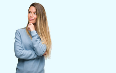 Sticker - Beautiful young woman wearing sweater and jeans serious face thinking about question, very confused idea