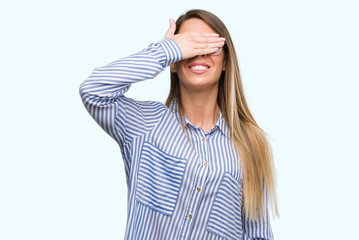 Canvas Print - Beautiful young woman wearing elegant shirt and glasses smiling and laughing with hand on face covering eyes for surprise. Blind concept.