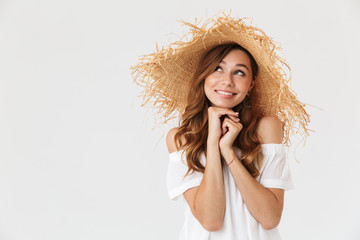 Sticker - Photo of elegant content girl 20s wearing big straw hat smiling and looking upward at copyspace with innocent glance, isolated over white background