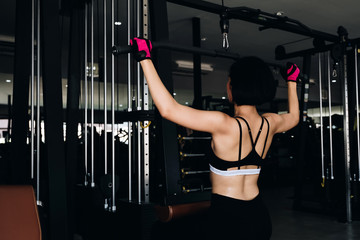 young fitness woman execute exercise with exercise-machine in gym