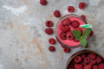 Raspberry smoothie in a glass on a grey background