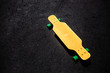 Yellow plastic longboard on the asphalt surface