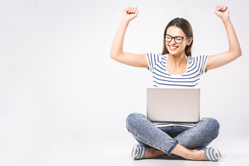 Wall Mural - Business concept. Portrait of happy woman in casual sitting on floor in lotus pose and holding laptop isolated over white background.