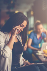 Wall Mural - Young woman using mobile phone in front of her team in startup office