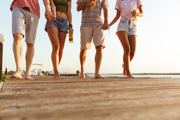 Poster - Group of friends walking outdoors on the beach.