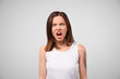 © EverGrump - Furious angry woman screaming with rage and frustration. Negative human emotions, face expressions. Portrait of a frustrated angry woman screaming out loud out isolated on the gray background