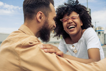 happy young multiethnic couple having fun and laughing on street